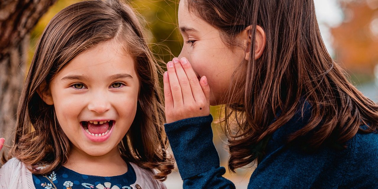 bambina-a-bocca-aperta-donna-gli-dice-una-cosa-nell’orecchio Pettegolezzi