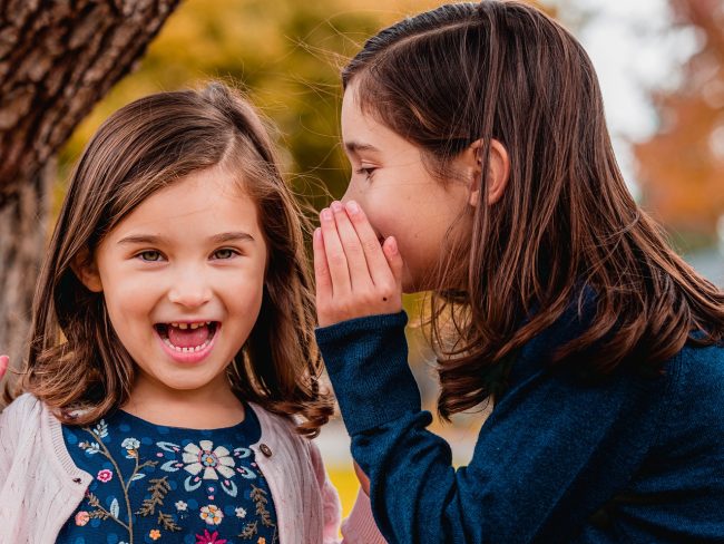 bambina-a-bocca-aperta-donna-gli-dice-una-cosa-nell’orecchio Pettegolezzi