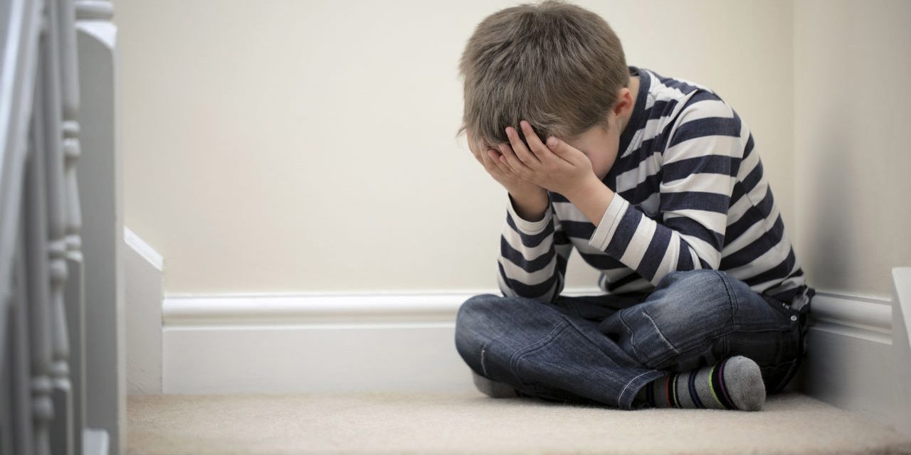 Bambino-seduto-a-gambe-incrociate-che-si-copre-il-volto Trauma