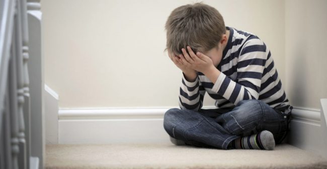 Bambino-seduto-a-gambe-incrociate-che-si-copre-il-volto Trauma